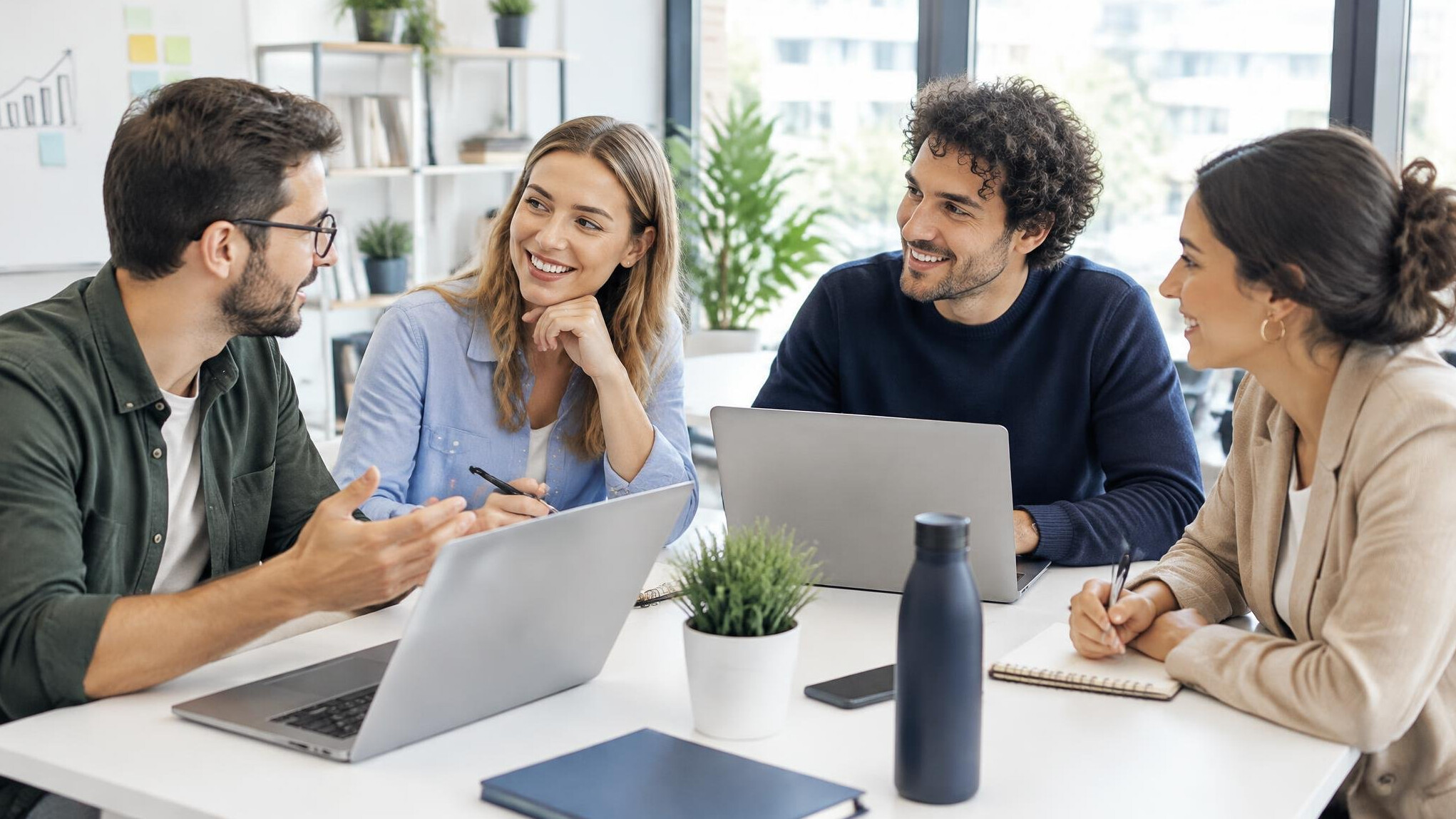 Group of young professionals studying together around a table with laptops